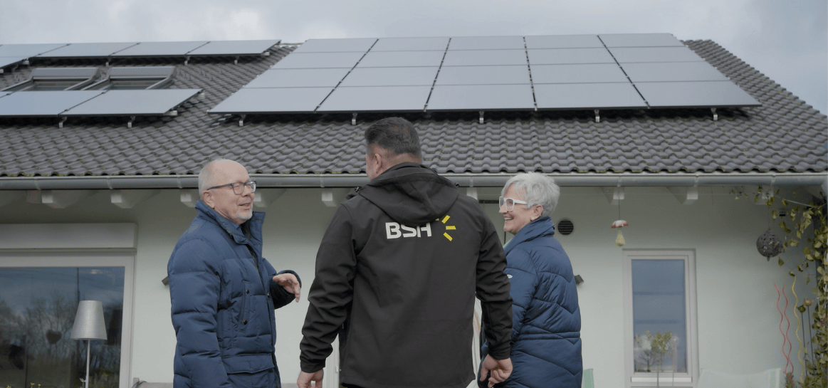 Kunden blicken mit Fachberater auf ihre Photovoltaikanlage