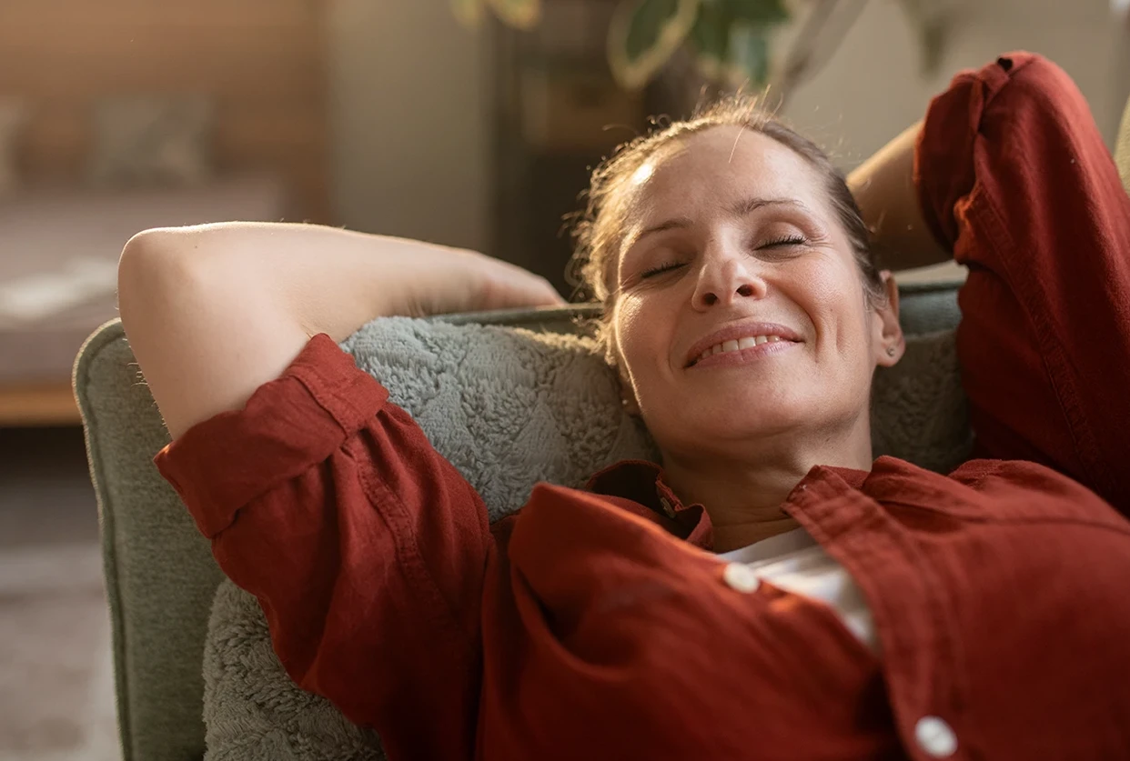 Frau liegt entspannt auf dem Sofa