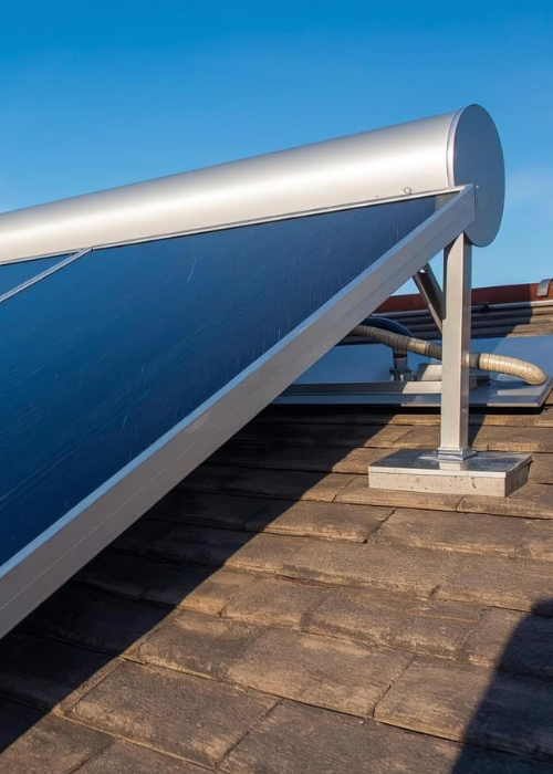 Großflächige Solarthermie-Kollektoren mit integriertem Warmwasserspeicher auf einem geneigten Hausdach, aufgenommen bei klarem, sonnigem Wetter