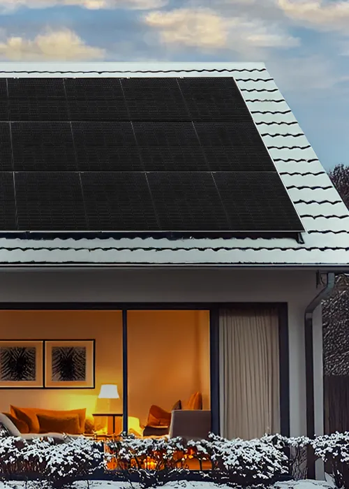 Einfamilienhaus mit PV-Modulen auf dem Dach im Winter.