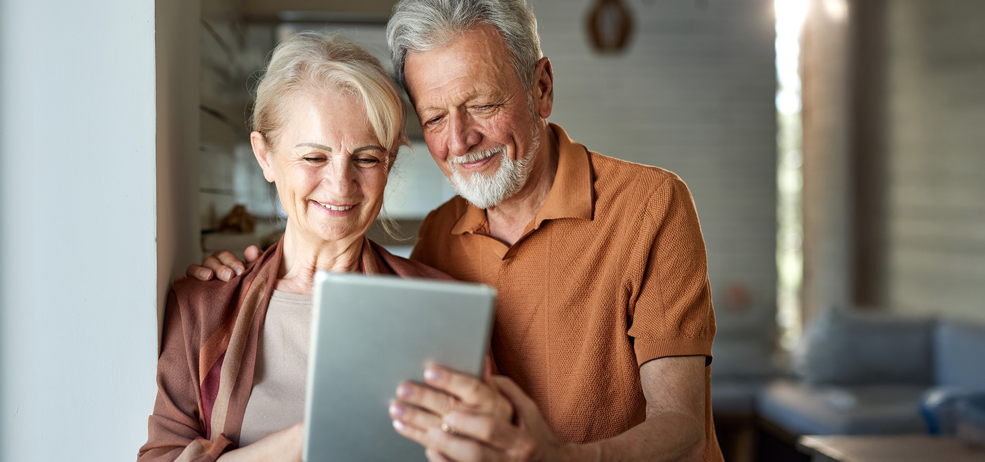 Ein älteres Paar blickt auf ein Tablet – Headerbild zum Ratgeber über Energiemanagementsysteme bei Photovoltaik.
