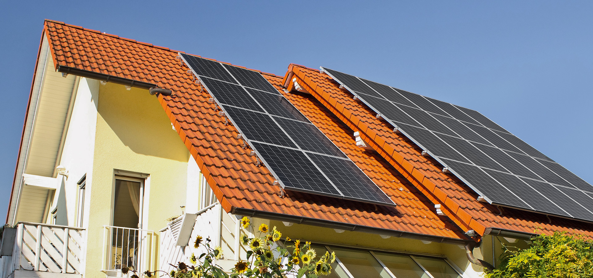 Ein Haus mit Photovoltaikanlage – Headerbild zum Ratgeber ‚Solaranlage mieten: Vor- und Nachteile‘.